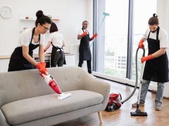 Focus on positive African American worker cleaning panoramic window.